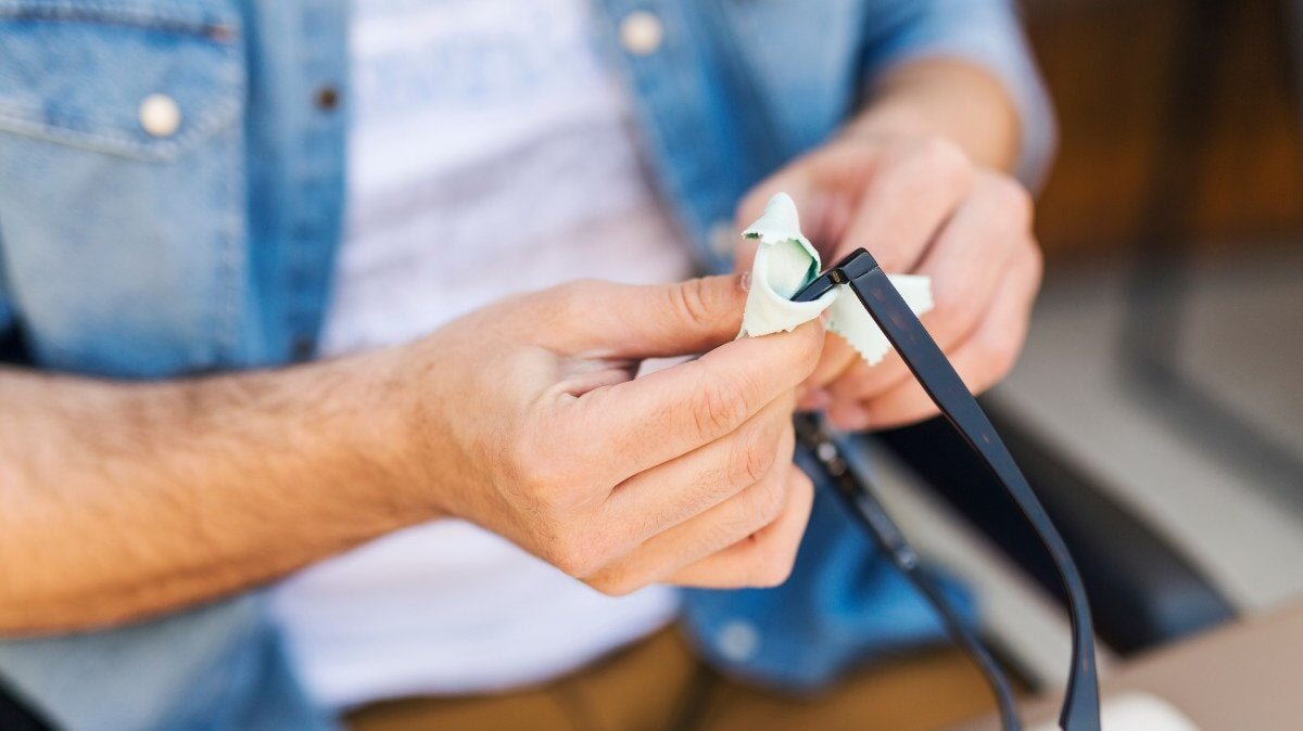 un homme nettoyant ses lunettes