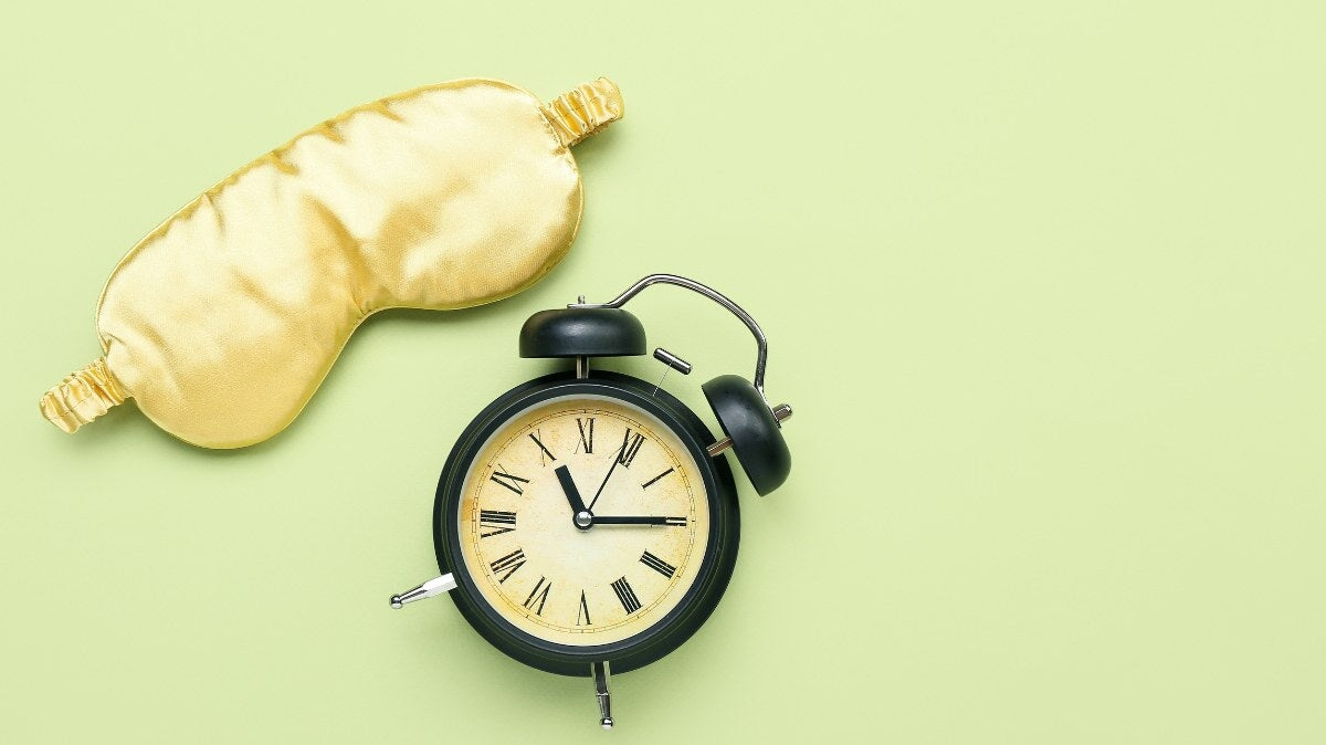 un masque de sommeil et une horloge sur une table