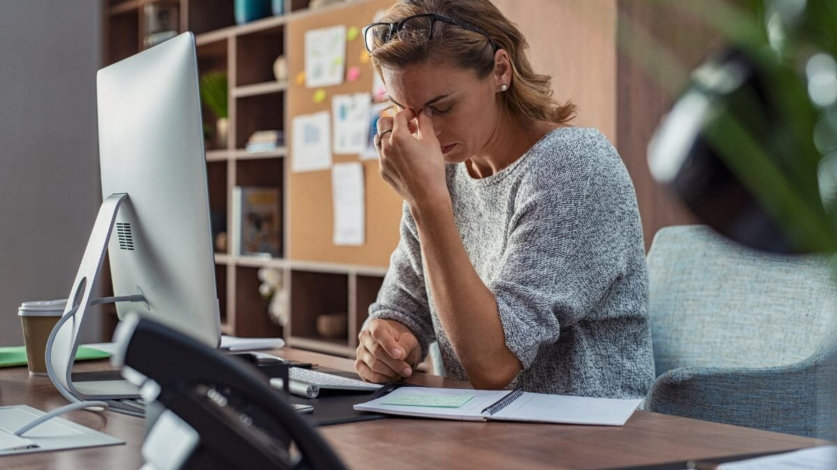 une femme ayant des maux de tête au bureau