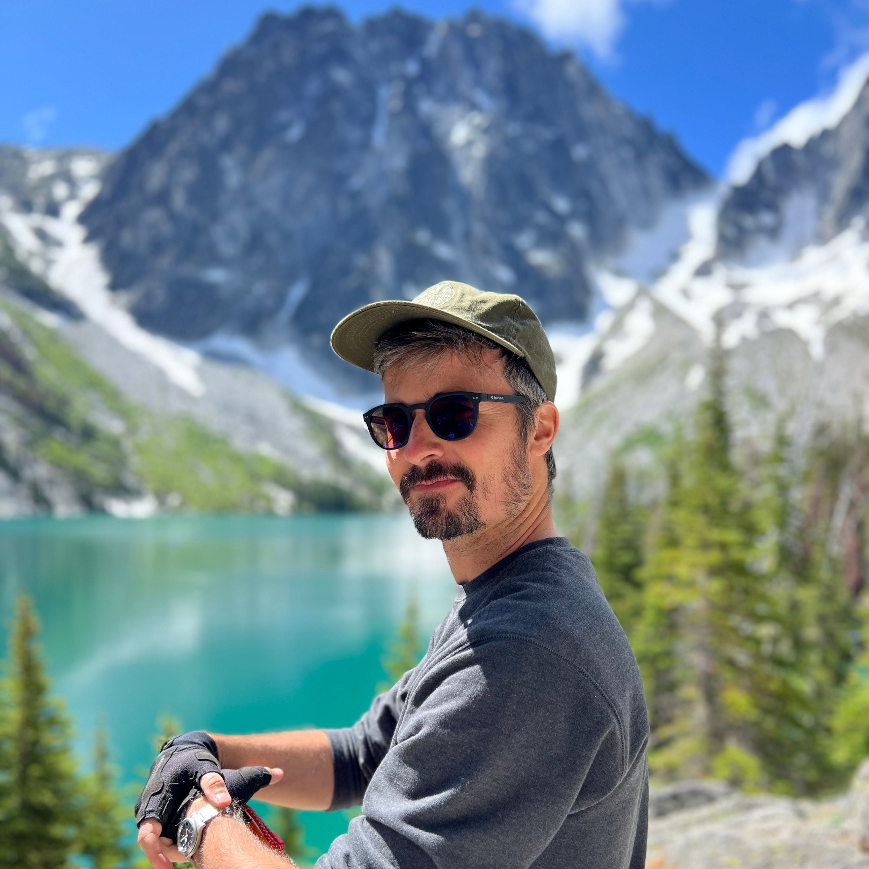 Paul porte les Urban Sun polarisées au bord d'un lac et des montagnes de Whistler