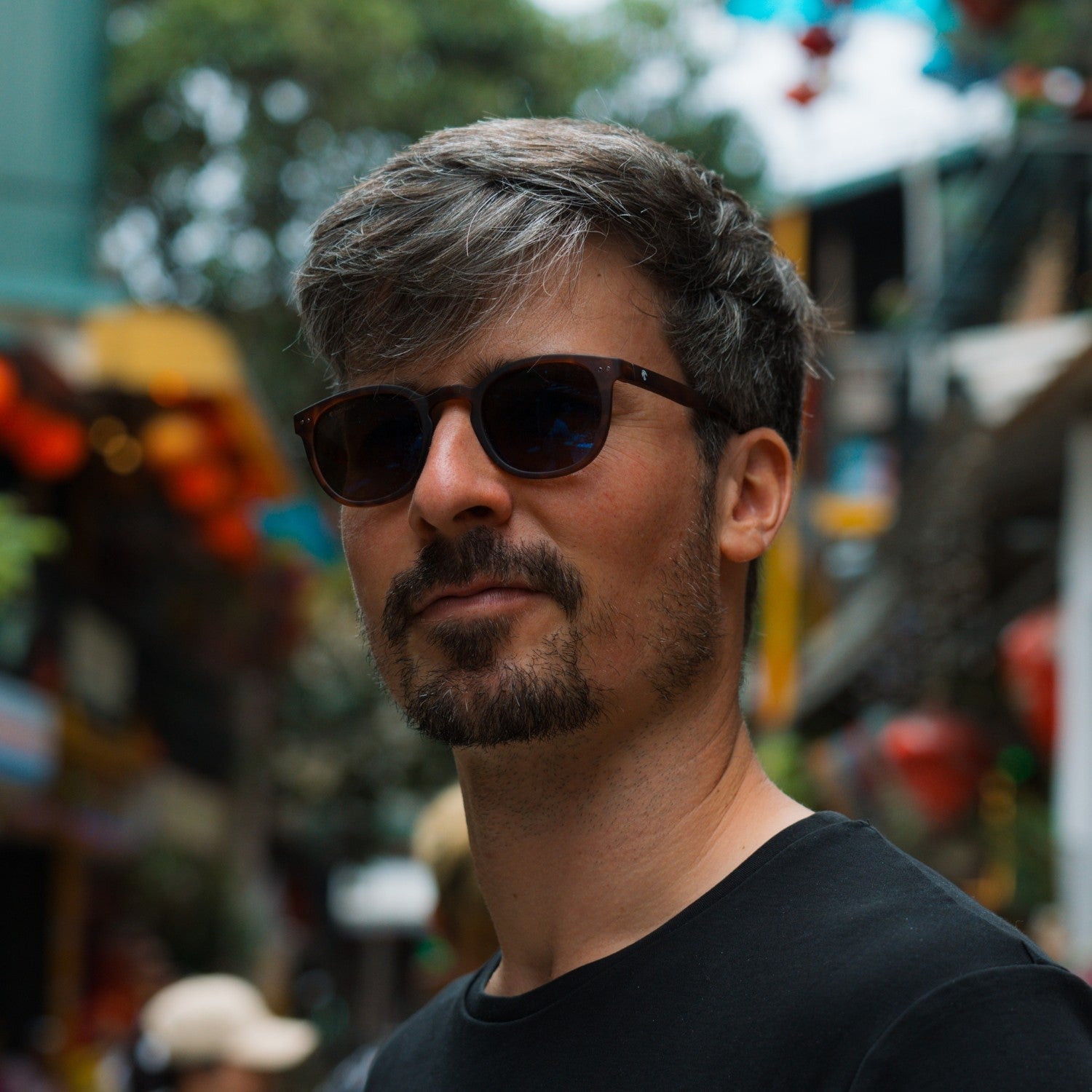 Notre cofondateur Paul porte les lunettes de soleil stockholm dans une rue colorée de Hanoi au Vietnam